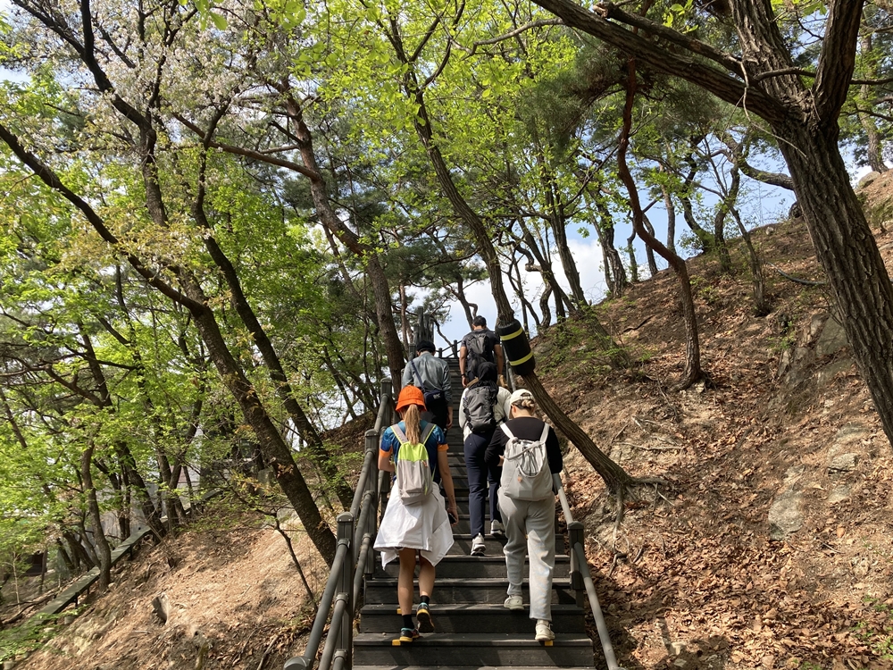 Para peserta program pertama Pusat Wisata Pendakian Gunung Seoul: Gunung Bugaksan terlihat sedang menaiki tangga Gunung Bugaksan pada tanggal 12 April. (Charles Audouin)