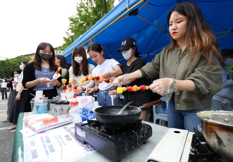 Mahasiswa dari Departemen Kesehatan Konvergensi membuat Tanghulu (makanan Tiongkok yang dimakan setelah mengeraskan buah dengan sirup yang terbuat dari gula dan sirup pati) di Universitas Wanita Ewha di Seodaemun-gu, Seoul, di mana Festival Daedong diadakan pada tanggal 14 September. Ewha Womans University, yang memulai kelas non-tatap muka pada Maret 2020 karena pandemi Covid-19 dan beralih ke kelas tatap muka mulai semester kedua tahun ini, mengadakan festival untuk pertama kalinya dalam tiga tahun sejak musim gugur 2019. (Yonhap News)