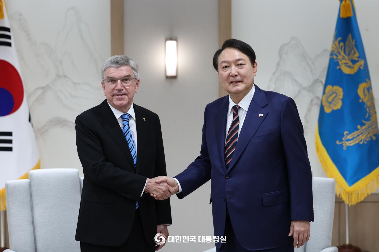 Presiden Yoon Suk Yeol (kanan) berjabat tangan dengan Ketua IOC, Thomas Bach (kiri), di Kantor Kepresidenan Yongsan tanggal 17 Oktober. 