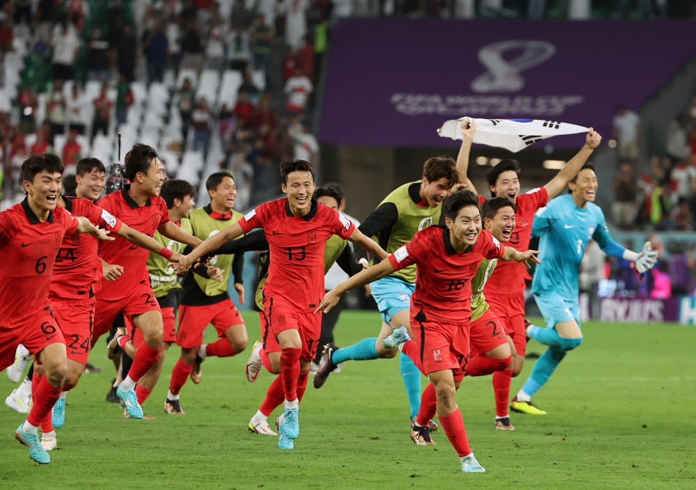 Timnas sepak bola Korea Selatan dengan gembira berlari ke lapangan mendengar kabar bahwa mereka telah melaju ke babak 16 besar setelah mengalahkan Portugal 2-1 pada pertandingan ketiga Grup H Piala Dunia Qatar 2022 yang diadakan di Stadion Kota Pendidikan di Al Rayyan, Qatar pada tanggal 2 Desember (waktu setempat).