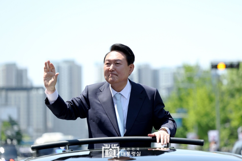 Presiden Yoon Suk Yeol memberikan salam dari dalam mobil kepada masyarakat yang hadir pada hari pelantikan yang digelar pada tanggal 10 Mei 2022 di Majelis Nasional, Yeouido, Seoul. Pemerintahan Presiden Yoon mengambil moto Republik Korea, Lagi! Negara Baru untuk Rakyat! Presiden Yoon berjanji akan membuat negara di mana masyarakat akan menjadi pemimpinnya. Presiden Yoon mengungkapkan bahwa negara yang ia kejar adalah negara yang memiliki landasan kebebasan, hak asasi manusia, keadilan, dan aliansi. (Kantor Kepresidenan Republik Korea) 