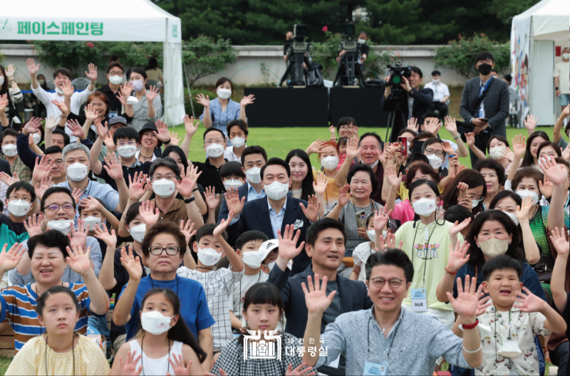 Presiden Yoon Suk Yeol berfoto bersama masyarakat setempat yang hadir dalam upacara peresmian Kantor Kepresidenan Republik Korea yang pindah ke Yongsan. Acara ini diselenggarakan pada tanggal 19 Juni 2022 di lapangan rumput yang berada di depan Kantor Kepresidenan Republik Korea, Yongsan-gu, Seoul. Tujuan pemindahan kantor kepresidenan adalah untuk berkomunikasi dengan masyarakat sehingga Presiden Yoon memulai tugas-tugas kenegaraannya pada tanggal 10 Mei 2022 di kantor yang terletak di Kementerian Pertahanan, Yongsan-gu, Seoul. (Kantor Kepresidenan Republik Korea) 