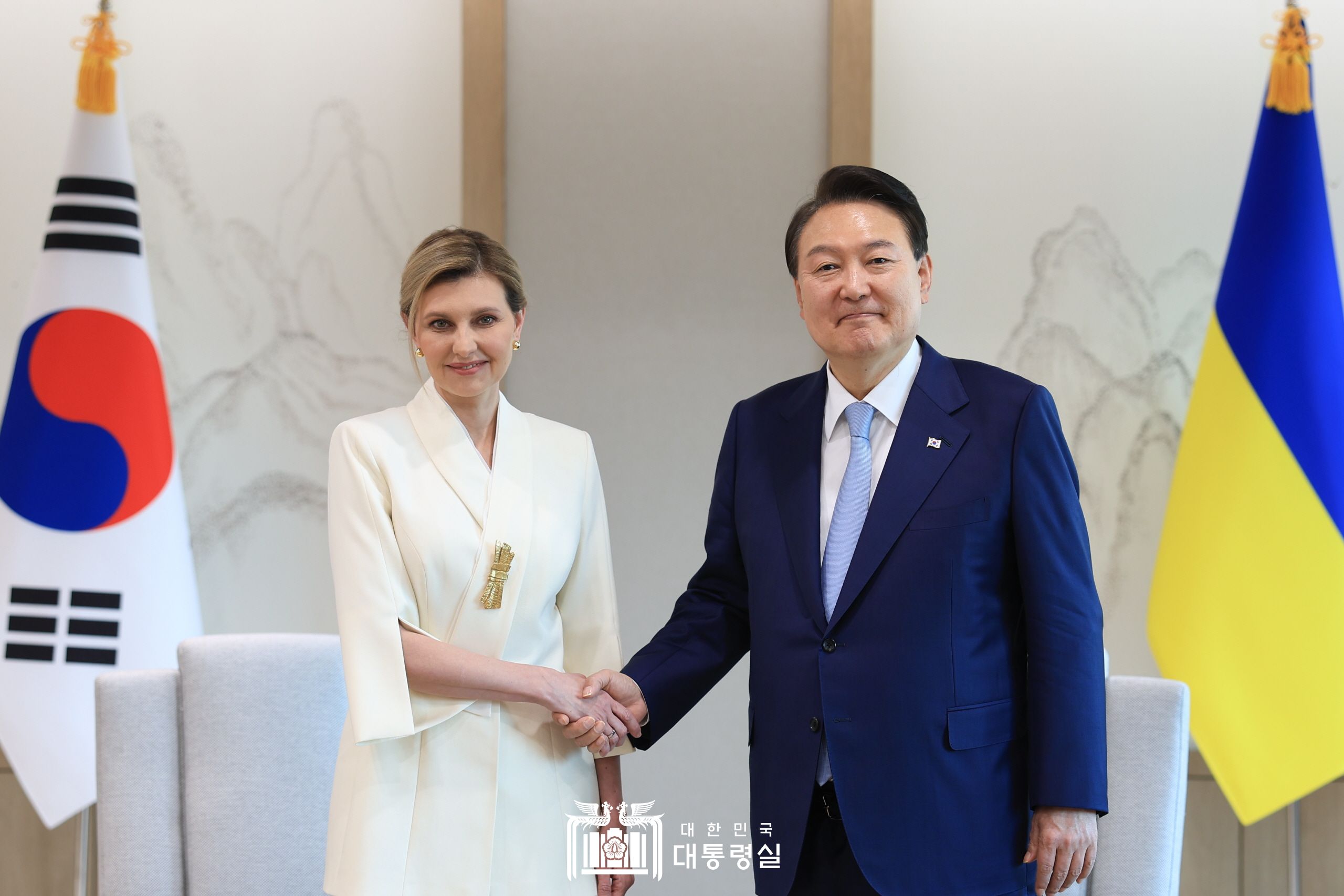 Presiden Yoon Suk Yeol (kanan) berjabat tangan dengan Ibu Negara Olena Zelenska, istri dari Presiden Ukraina, Volodymyr Zelenskyy. Pertemuan itu diselenggarakan pada tanggal 16 Mei di Kantor Kepresidenan Republik Korea, Yongsan, Seoul. 