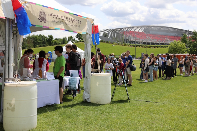 Pada tanggal 10 Juni (waktu setempat), para pengunjung berbaris di stan Institut of Traditionl Korean Food di K-Fest yang diadakan di Taman Lansdowne, Ottawa, Kanada.