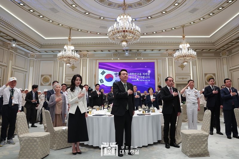 Presiden Yoon Suk Yeol, Ibu Negara Kim Keon Hee, dan para tamu undangan jamuan makan siang memberikan hormat kepada bendera nasional Korea pada tanggal 14 Juni di Yeongbingwan, Cheong Wa Dae. 