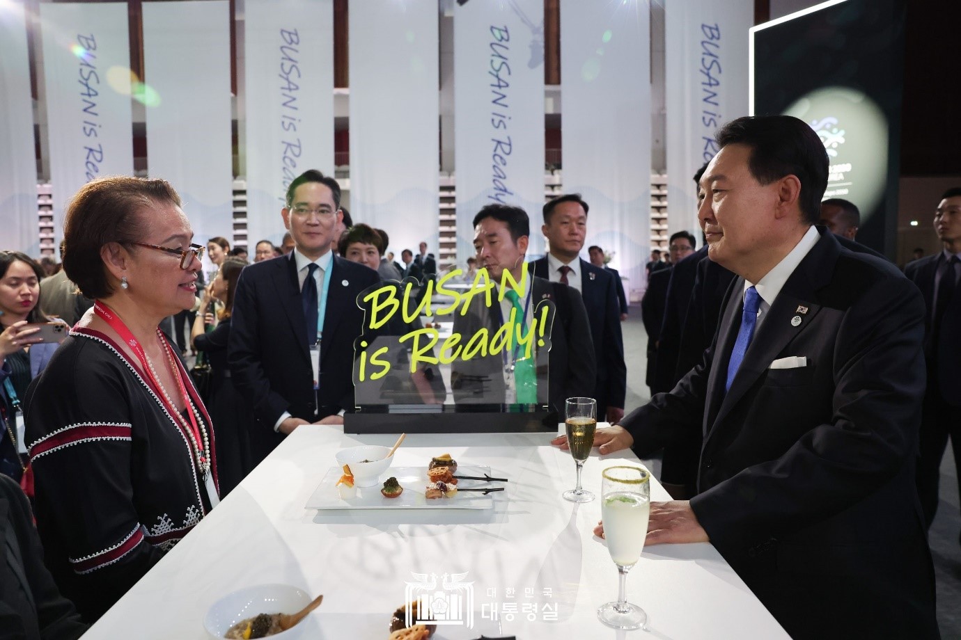  Presiden Yoon Suk Yeol (kanan) menyapa para tamu undangan yang hadir dalam Resepsi World Expo 2030 Busan yang digelar pada tanggal 21 Juni (waktu setempat) di sebuah pusat olahraga yang terletak di Issy-les-Moulineaux, Paris, Prancis. Presiden Yoon memberikan hadiah kepada perwakilan tamu yang hadir berupa paket prangko BTS yang menjadi duta promosi World Expo 2030 Busan dan gantungan kunci BUSAN IS READY yang didesain oleh Ibu Negara Kim Keon Hee.