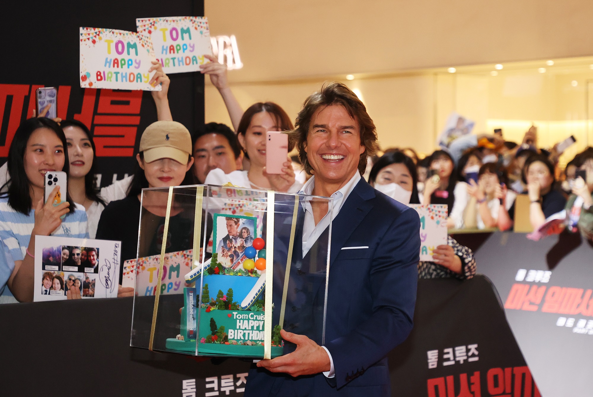 Tom Cruise menerima hadiah kue ulang tahun dari para penggemarnya saat menghadiri acara karpet merah film Mission: Impossible Dead Reckoning Part One yang digelar pada tanggal 29 Juni di Lotte World Mall, Songpa-gu, Seoul. (Yonhap News) 