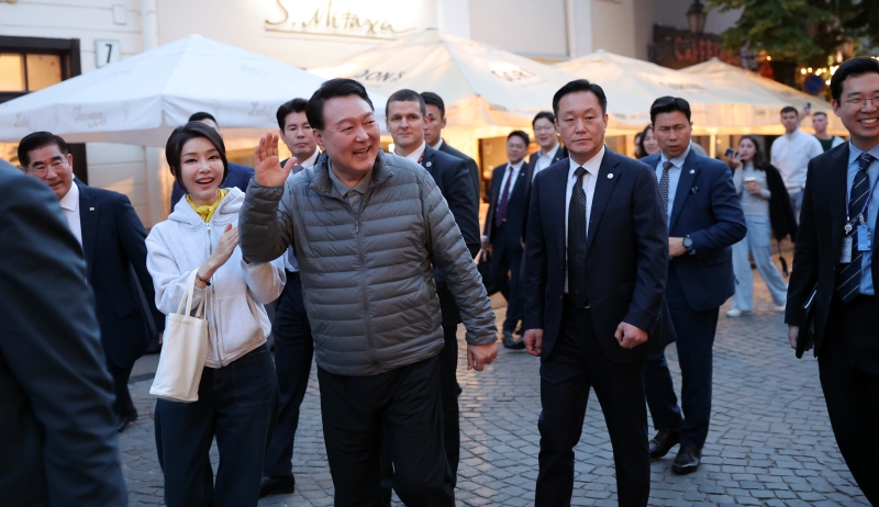 Presiden Yoon Suk Yeol dan Ibu Negara Kim Keon Hee menyapa Senator AS, Pete Ricketts, yang sedang makan di sebuah restoran luar rungan yang berada di sebuah jalan di Vilnius pada tanggal 10 Juli (waktu setempat). (Yonhap News) 