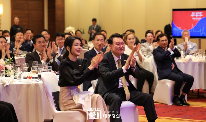 Presiden Yoon Suk Yeol (kanan) dan Ibu Negara Kim Keon Hee bertepuk tangan pada pertemuan warga negara Korea yang diadakan di sebuah hotel di Warsaw, Polandia. 