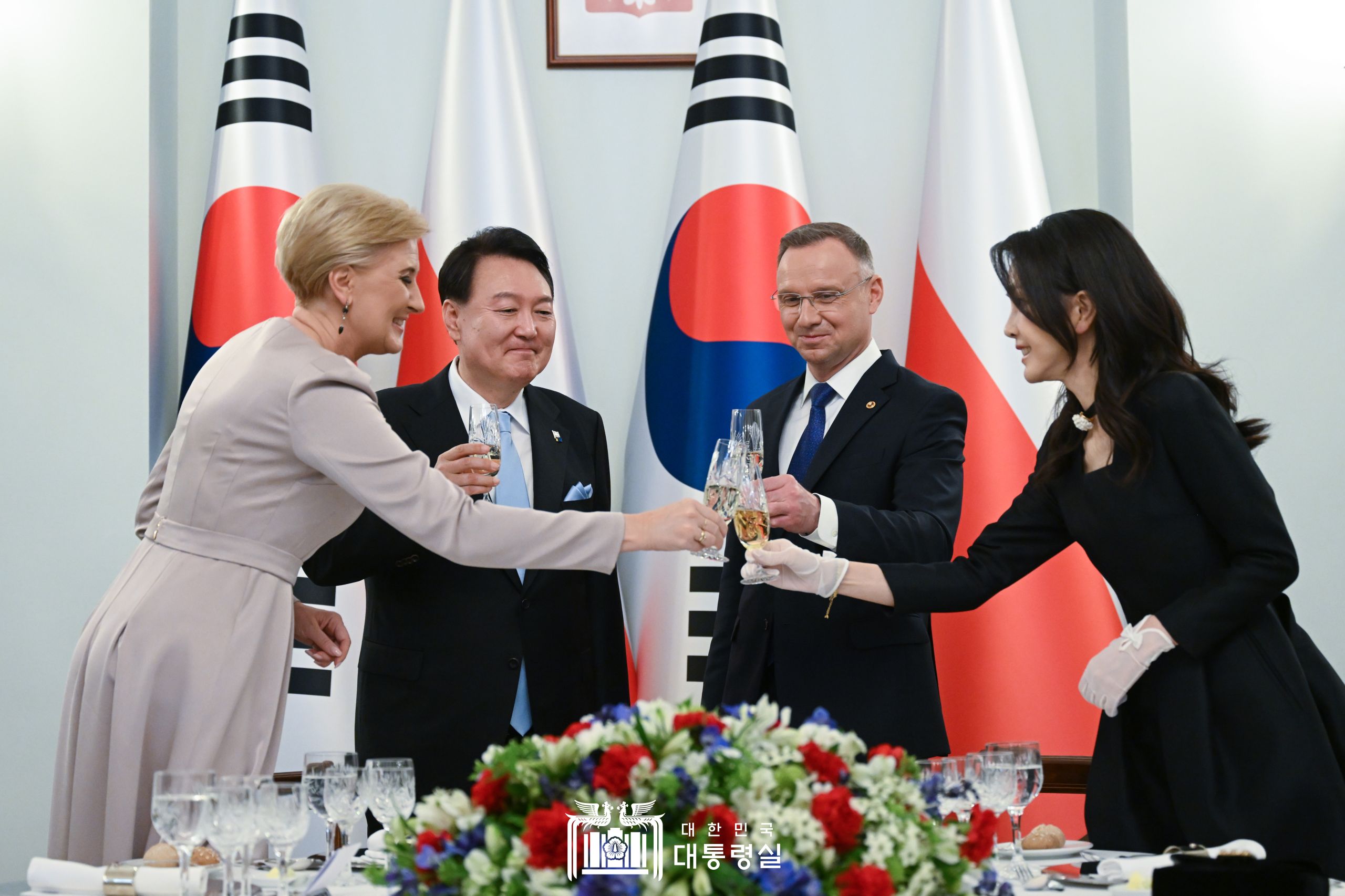 Presiden Yoon Suk Yeol (kedua dari kiri) bersulang dengan Ibu Negara Kim Keon Hee (pertama dari kanan), Presiden Polandia Andrzej Duda (kedua dari kanan), dan Ibu Negara Polandia Agata Kornhauser-Duda pada tanggal 13 Juli (waktu setempat) dalam jamuan makan malam di Istana Presiden Polandia. 