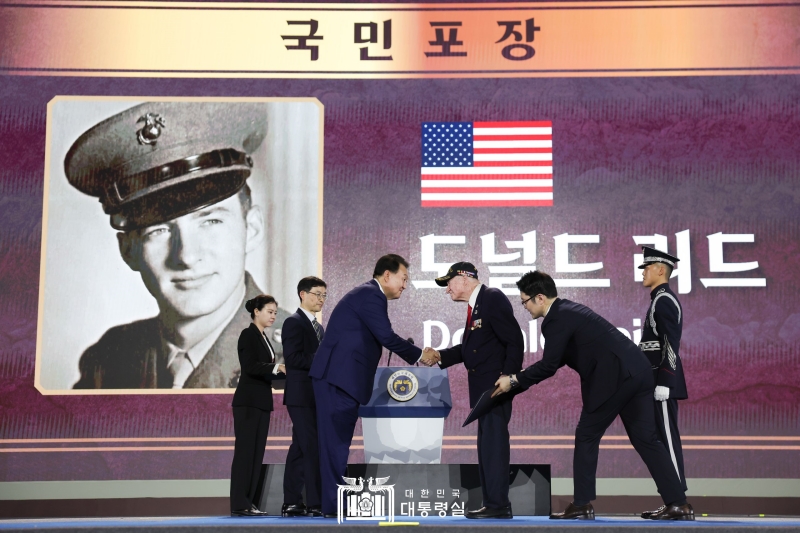 Presiden Yoon Suk Yeol (ketiga dari kiri) meanugerahi tanda pangkat nasional kepada veteran perang pasukan AS, Sersan Donald Reid pada Upacara Hari Peringatan 70 Tahun Gencatan Senjata dan Hari Peringatan Veteran Perang Korea dari Pasukan PBB yang digelar pada tanggal 27 Juli di teater terbuka Busan Cinema Center di Haeundae-gu, Busan.