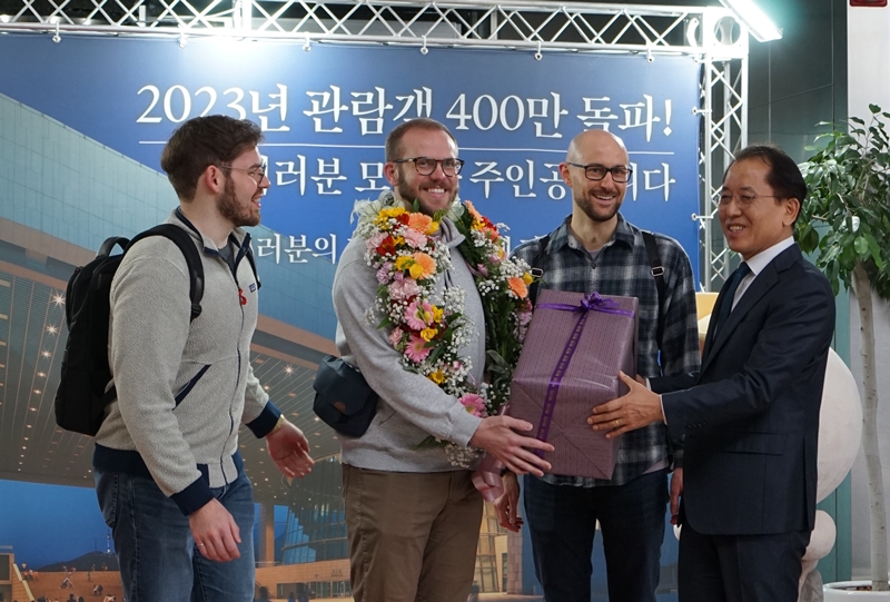 Sam Nicoles (kedua dari kiri) mendapatkan hadiah pada tangal 13 Desember dari Yoon Sung Yong (kanan), Direktur Museum Nasional Korea, setelah menjadi pengunjung keempat juta Museum Nasional Korea pada tahun 2023. (Museum Nasional Korea) 