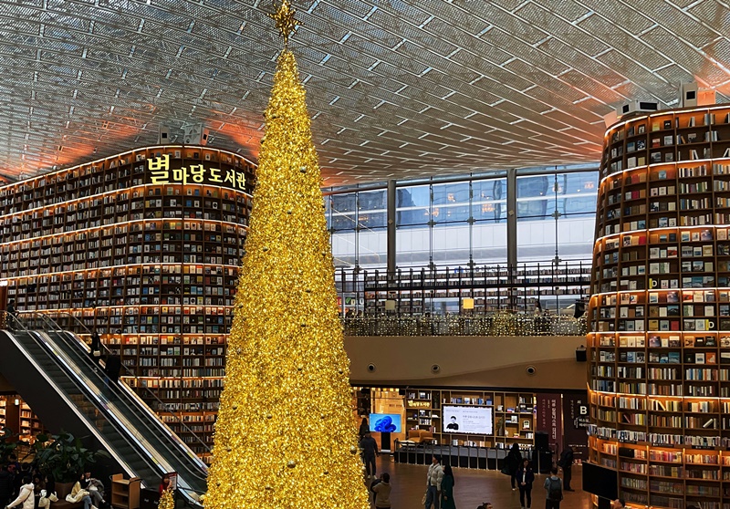 Perpustakaan Starfield yang berada di dalam COEX adalah sebuah ruang budaya dengan 70 ribu jilid buku yang berada di dalamnya. Untuk menyambut Natal, pohon Natal raksasa setinggi 11 meter berwarna keemasan selalu dipasang di tengah perpustakaan tersebut. Selain itu, para pengunjung juga bisa menikmati seni media bertema Natal pada rak buku setinggi 13 meter yang ada di dalam perpustakaan. (Lee Da Som)