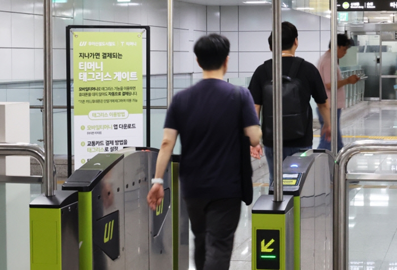 Seorang warga terlihat melewati gerbang pembayaran yang ada di dalam stasiun kereta di Seoul tanpa mengetap kartu karena stasiun terkait sudah menerapkan sistem transportasi umum nirsentuh. (Pemerintah Kota Seoul)