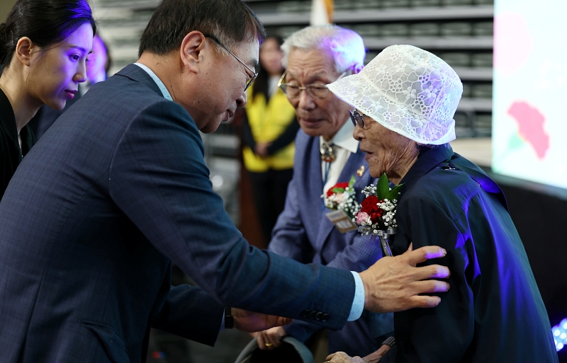Wakil Wali Kota Seoul, Kim Sang-han terlihat sedang menyematkan bunga anyelir merah kepada Park Tae Nam (96 tahun) dan Kim Ok Rye (93 tahun) pada acara peringatan Hari Orang Tua yang diselenggarakan oleh Pemerintah Kota Seoul pada tanggal 8 Mei di Jangchung Arena, Jung-gu, Seoul. (Yonhap News)