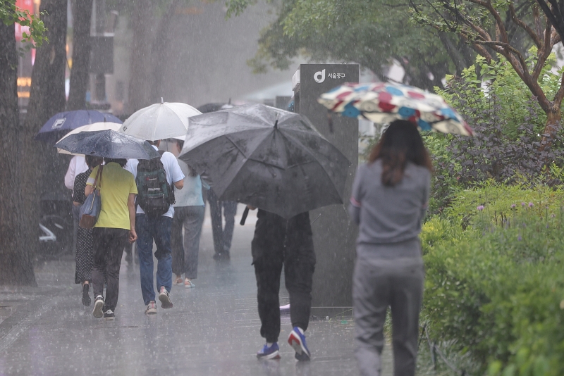 Warga terlihat sedang berjalan pada tanggal 2 Juli di sekitar Stasiun Balai Kota di Jalur 2 Metro Seoul. Hujan lebat turun di seluruh Korea, terutama di wilayah tengah. Pada hari itu, Administrasi Meteorologi Korea mengeluarkan peringatan hujan lebat di seluruh Seoul. (Yonhap News)