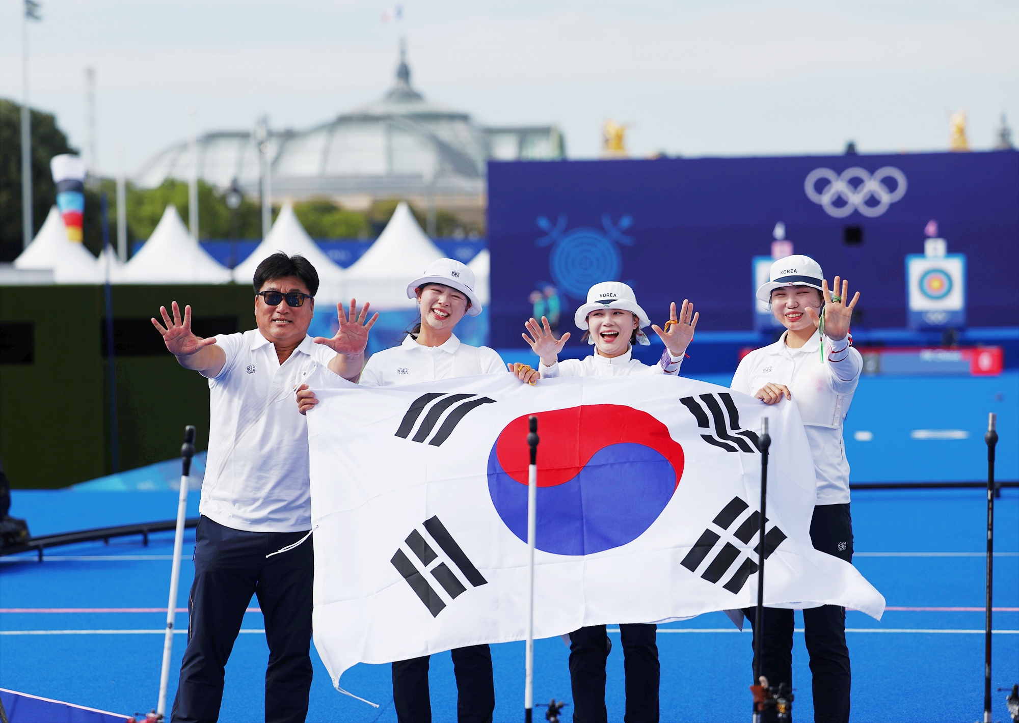 Tim nasional panahan beregu putri Korea berfoto bersama dengan bendera nasional Korea setelah meraih medali emas Olimpiade Paris 2024 pada tanggal 28 Juli (waktu setempat) di Paris, Prancis. Dari kiri ke kanan: Pelatih Yang Changhoon bersama atlet asuhannya, yaitu Lim Sihyeon, Jeon Hunyoung, dan Nam Suhyeon.   