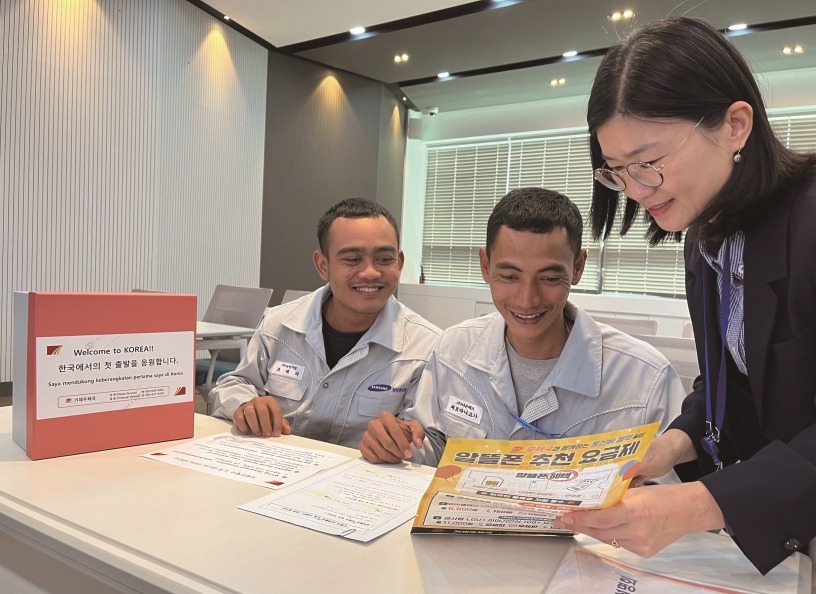 Pemerintah Kota Seoul mengungkapkan pada tanggal 27 September 2024 bahwa perjanjian kerja sama telah ditandatangani dengan Kantor Pos Wilayah Seoul untuk memberikan bantuan diskon penggunaan EMS kepada penduduk WNA. Foto di atas menunjukkan dua orang pekerja asing yang sedang mendengarkan penjelasan mengenai produk kantor pos dan layanan finansial. (Korea Post)