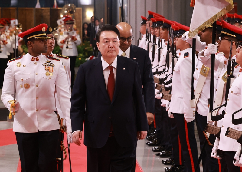 Presiden Yoon Suk Yeol terlihat sedang menginspeksi pengawal kehormatan bersama Presiden Singapura Tharman Shanmugaratnam pada upacara penyambutan resmi yang digelar pada tanggal 8 Oktober 2024 (waktu setempat) di Parlemen Singapura. (Yonhap News)