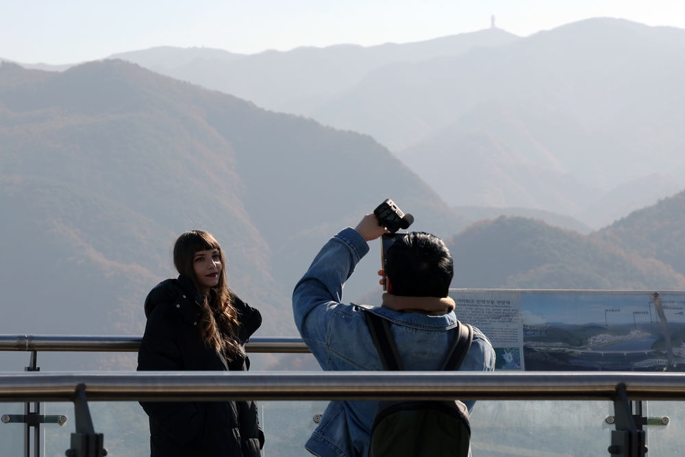 K-influencer Aiyaphat Wankawisant dari Thailand terlihat sedang mengambil foto wartawan kehormatan Yunani Foteini Chatzoudi pada tanggal 6 November 2024 di puncak Mancheonha Skywalk, Danyang-gun, Provinsi Chungcheongbuk.