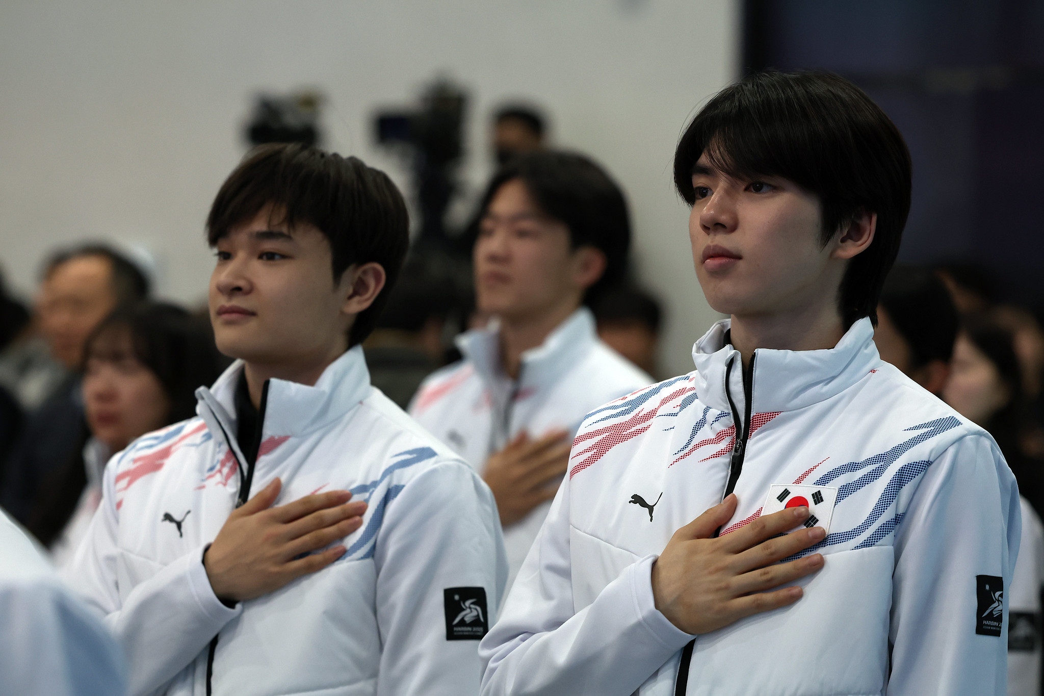 Atlet seluncur indah Cha Junhwan (kanan) dan Kim Hyungyeom terlihat sedang memberikan hormat kepada bendera nasional Korea pada Upacara Pelepasan Tim Nasional Korea untuk Harbin 2025 yang digelar tanggal 24 Januari 2025 di Aula Olimpiade, Taman Olimpiade, Seoul.