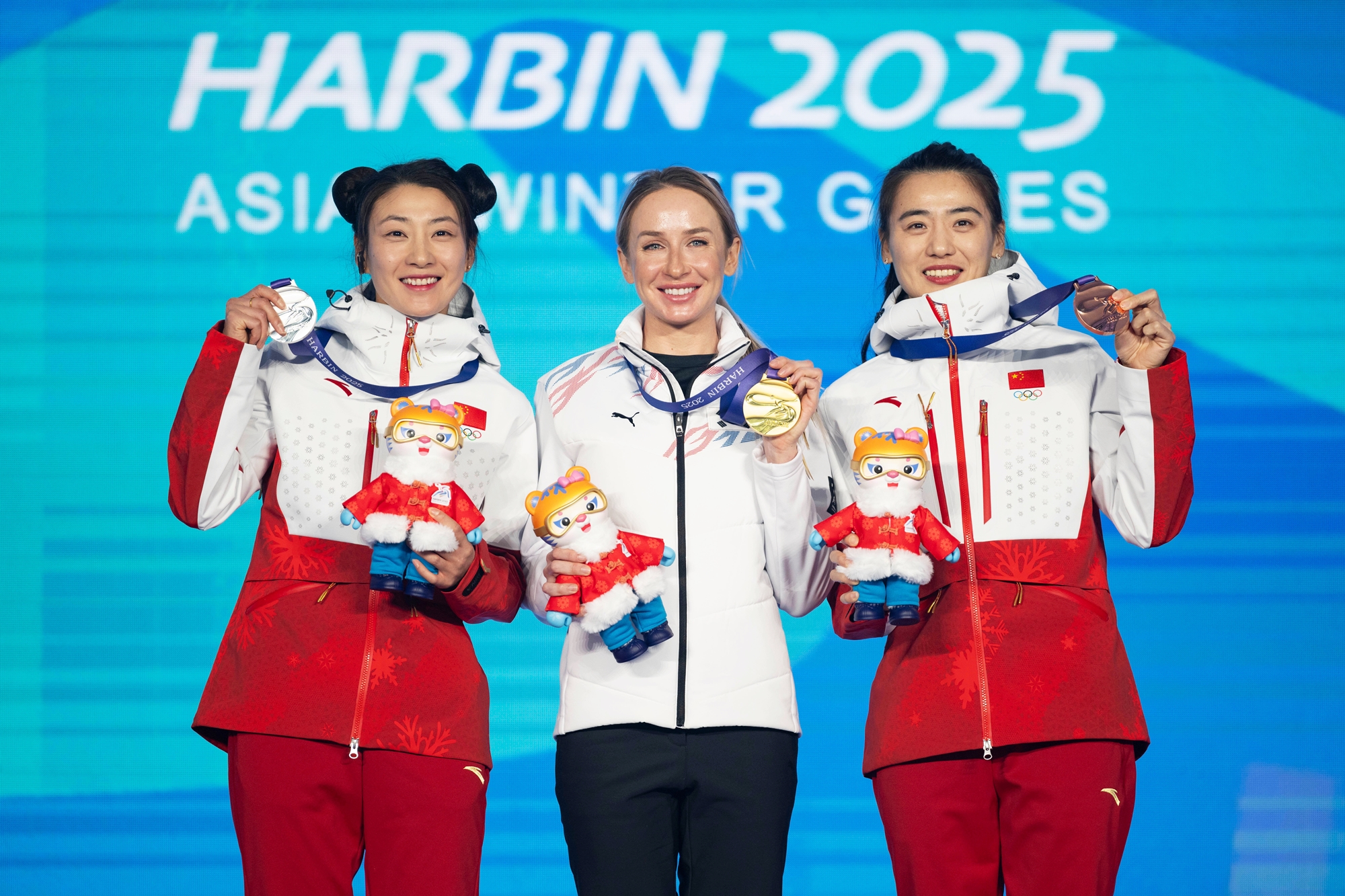 Avvakumo Ekaterina (tengah) berfoto bersama peraih medali perak dan perunggu setelah menjuarai nomor biatlon perorangan putri 7,5 km sprint dengan catatan waktu 22:45.4 pada tanggal 11 Februari 2025 di Yabuli Ski Resort, Harbin, Tiongkok.  