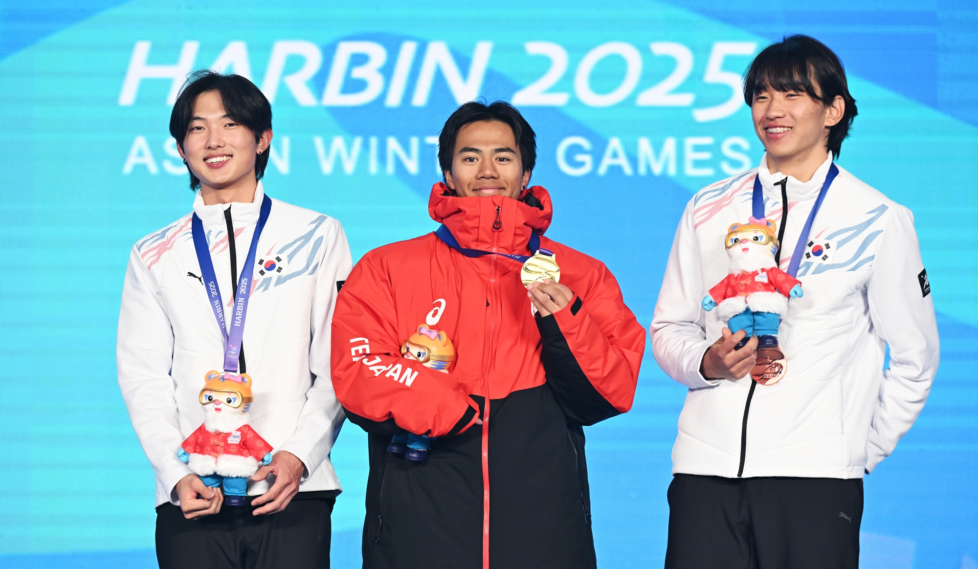 Yoon Jonghyun (kiri) berfoto bersama peraih medali emas asal Jepang Rai Kasamura (tengah) dan peraih medali perunggu asal Korea Shin Yeongseop (kanan) setelah menyelesaikan babak final nomor ski gaya bebas big air perorangan putra yang digelar pada tanggal 12 Februari 2025 di Yabuli Ski Resort, Harbin, Tiongkok. (Yonhap News)  