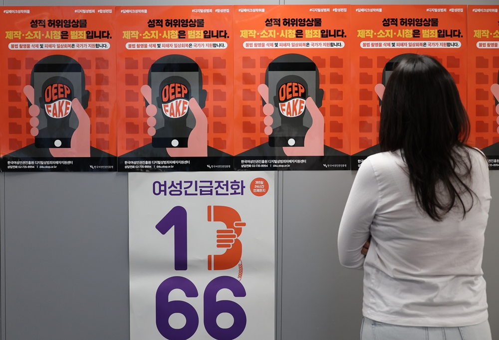Seorang pihak terkait terlihat sedang melihat poster terkait pencegahan kejahatan deepfake pada bulan November 2024 di Pusat Bantuan Korban Kejahatan Seksual di Ruang Digital, Institut Hak Asasi Wanita Korea. (Yonhap News)  