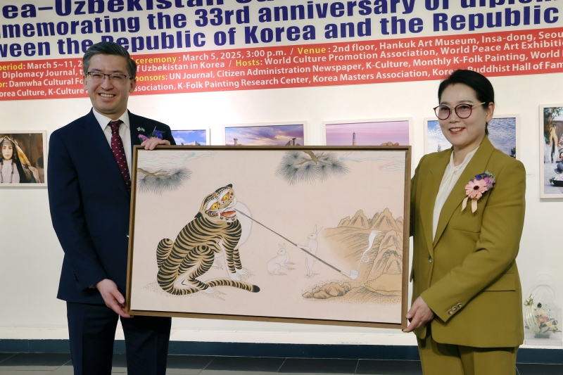 Duta Besar Uzbekistan untuk Korea Alisher Abdusalomov (kiri)berpose bersama Lee Mi Hyung dalam upacara pemberian donasi karya Lee di Pameran Pertukaran Budaya untuk Memperingati 33 Tahun Hubungan Diplomatik Korea dan Uzbekistan pada tanggal 5 Maret 2025 di Galeri Korea, Insadong, Jongno-gu, Seoul.