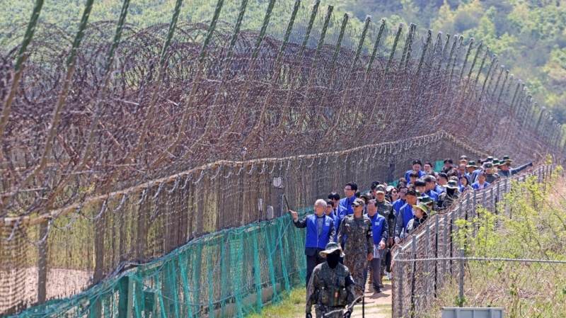 Menteri Kebudayaan, Olahraga, dan Pariwisata Yu In Chon berjalan menyusuri bagian jalur berpagar kawat berduri di Jalur Perdamaian DMZ, Goseong, Provinsi Gangwon, bersama para peserta program Local 100. (Kementerian Kebudayaan, Olahraga, dan Pariwisata)