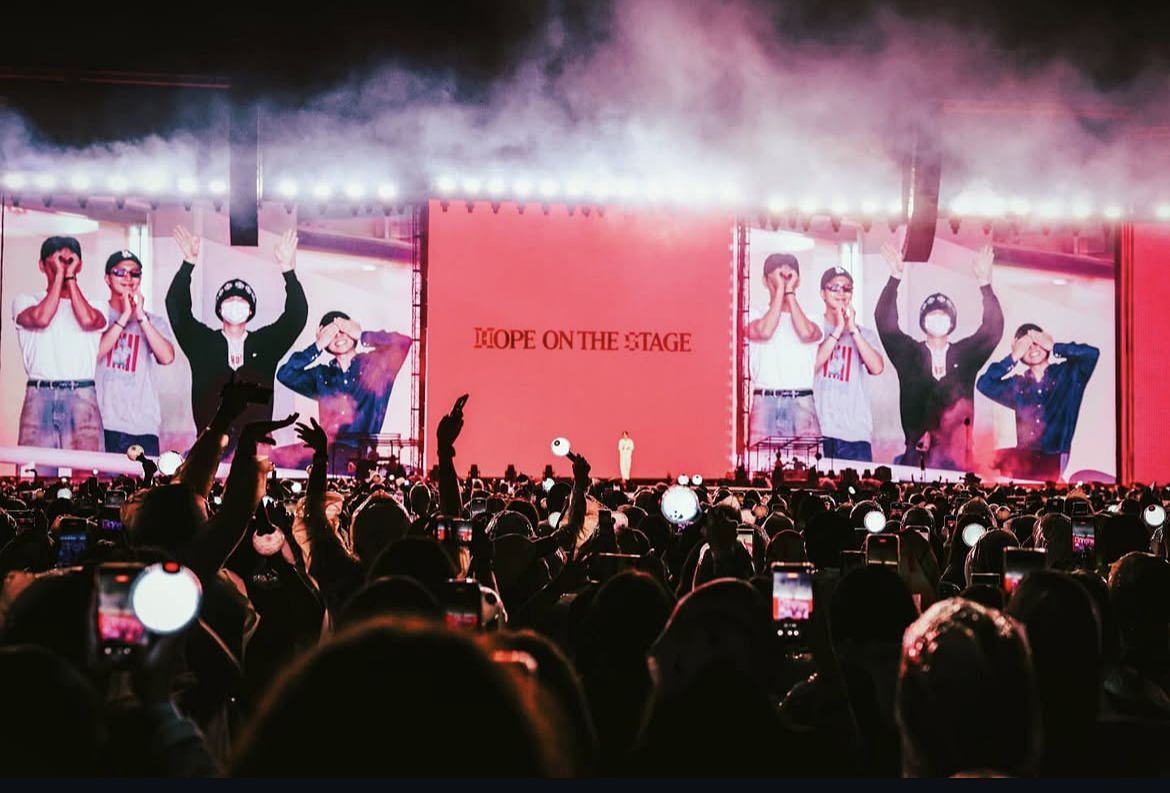 Jin dan Jung Kook muncul secara mengejutkan di atas panggung, sementara Suga, RM, Jimin, dan V menonton pertunjukan sambil duduk di bangku penonton bersama ARMY. (Tangkapan layar Instagram J-Hope)