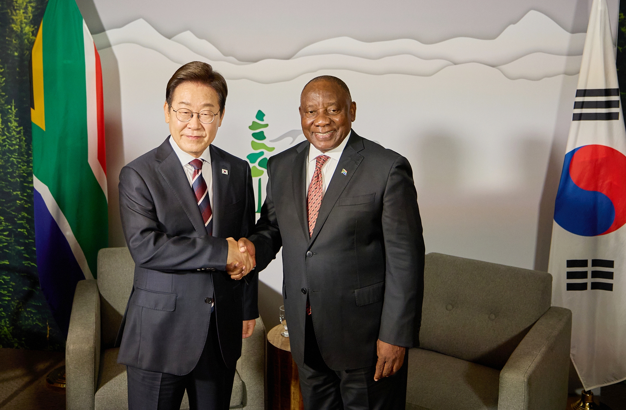 Presiden Lee Jae-myung (kiri) berjabat tangan dengan Presiden Afrika Selatan, Cyril Ramaphosa, pada tanggal 16 Juni 2025 (waktu setempat) di sebuah hotel yang terletak di Kota Calgary, Provinsi Alberta, Kanada. 