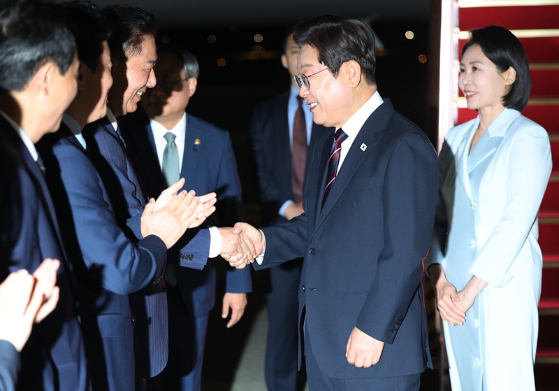 Presiden Lee Jae Myung (kedua dari kanan) menyapa ketua partai berkuasa saat tiba kembali di Korea pada tanggal 19 Juni 2025. (Yonhap News)  
