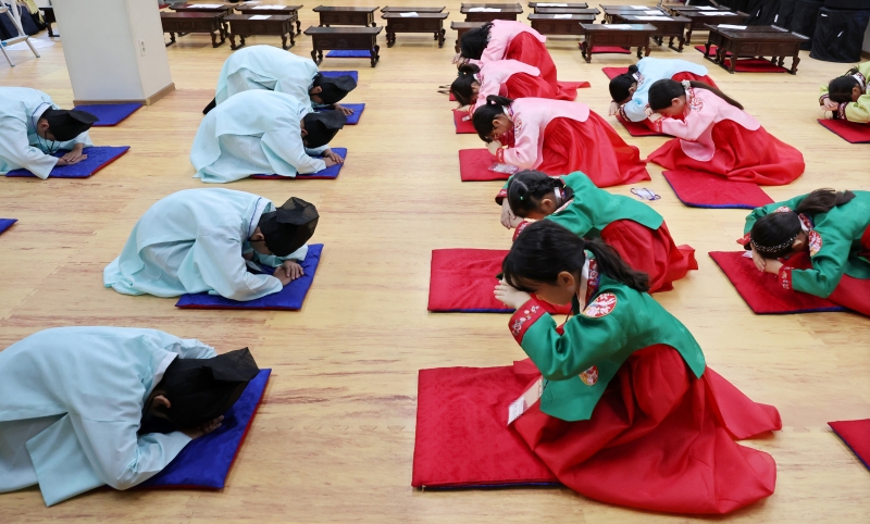 Beberapa orang siswa SD terlihat sedang mempelajari tata cara memberikan hormat dengan cara tradisional dalam kelas budaya tradisional yang digelar pada libur musim panas di Allak Seowon, Kuil Chungnyeolsa, Dongnae-gu, Kota Busan.  Foto tersebut diambil pada tanggal 28 Juli 2025 dan program terkait digelar hingga tanggal 1 Agustus 2025. Para peserta bisa mempelajari berbagai hal dalam program tersebut, mulai dari memberi hormat secara tradisional, menyanyikan lagu rakyat, hingga memainkan permainan tradisional Korea. (Yonhap News)