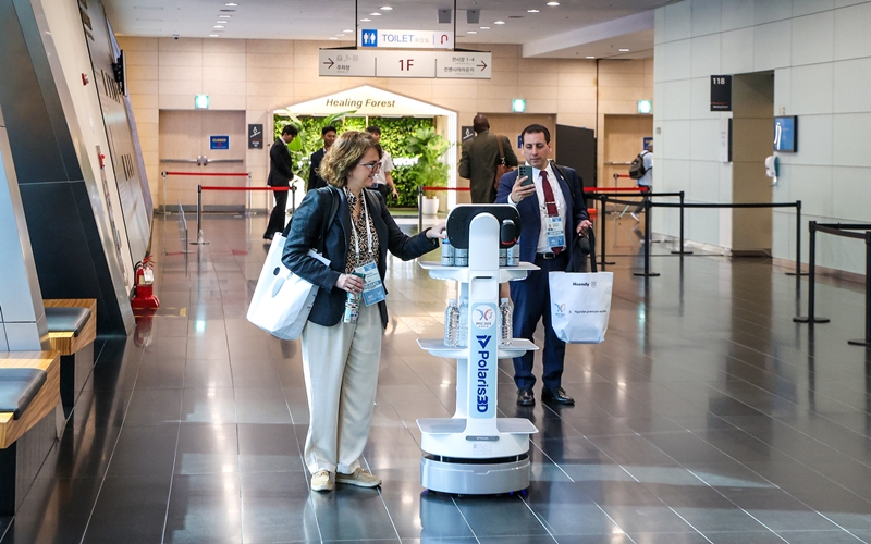 >Seorang tamu undangan terlihat sedang mengambil air dari robot dalam gelaran APEC SOME3 pada tanggal 5 Agustus 2025 di Songdo Convensia, Incheon. (Flickr resmi APEC 2025)