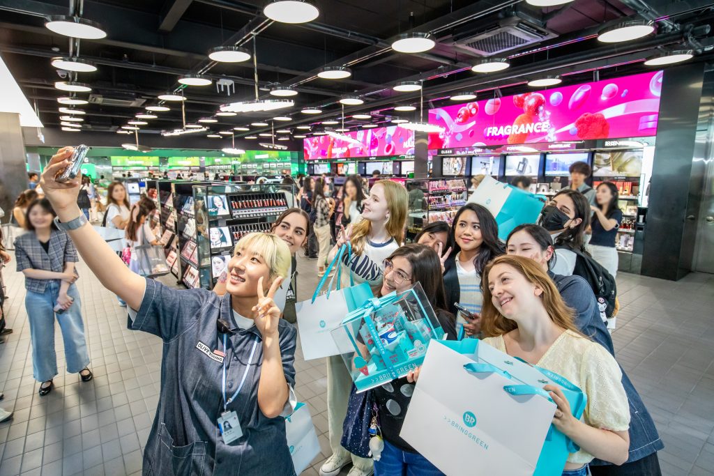 Berbagai media Korea termasuk Yonhap News melaporkan tren pengeluaran wisatawan asing di Korea pada tanggal 19 Agustus 2025. Foto di atas menunjukkan para wisatawan asing yang berfoto bersama pada bulan Juni 2024 di Olive Young Myeongdong Global Town, Jung-gu, Seoul. (CJ Olive Young)