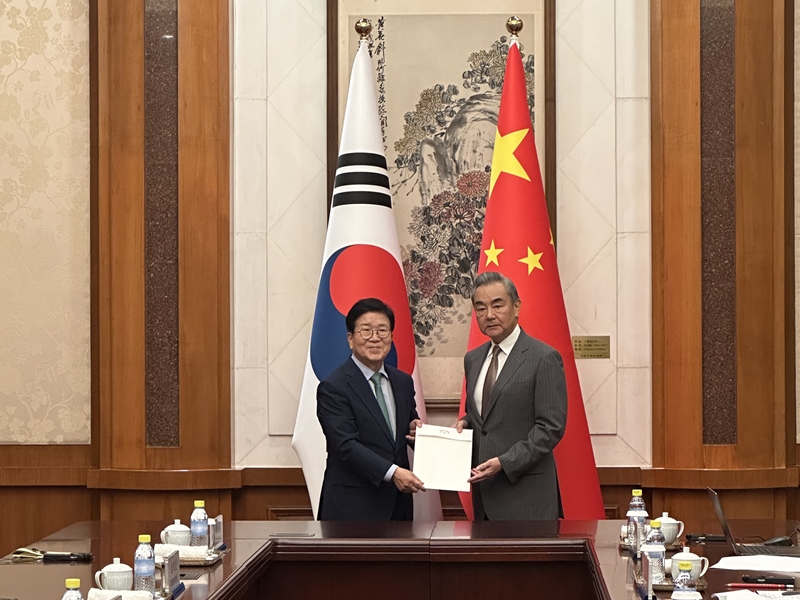 Mantan Ketua Majelis Nasional Park Beong-seug (kiri) yang memimpin delegasi khusus presiden ke Tiongkok pada tanggal 24 Agustus 2025 menyerahkan surat pribadi Presiden Lee Jae Myung kepada Menteri Luar Negeri Tiongkok Wang Yi di Diaoyutai State Guesthouse, Beijing. (Kementerian Luar Negeri)
