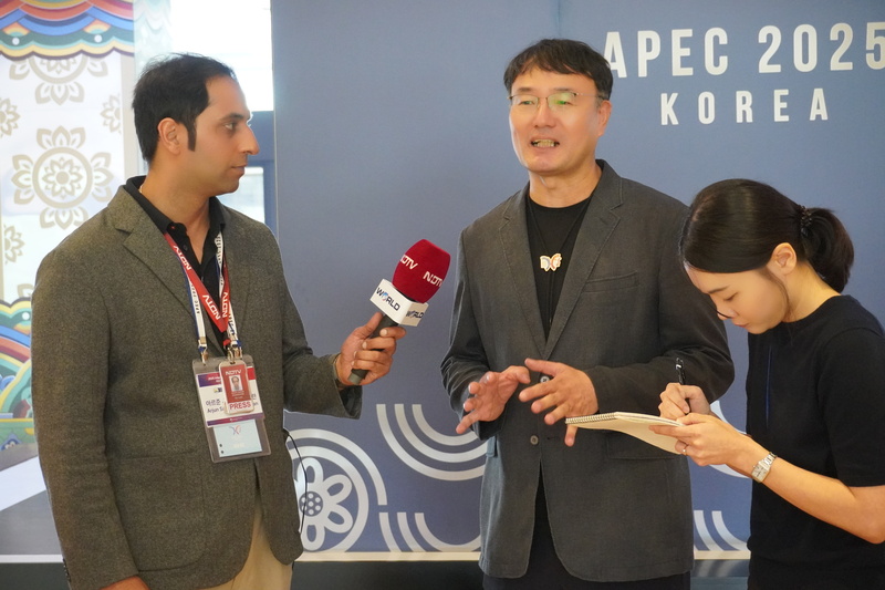 Arjun Samar Mahendran (kiri) dari NDTV India pada tanggal 27 Agustus 2025 mewawancarai Park Jang Ho (tengah), Direktur Kantor Persiapan dan Dukungan APEC, di Hotel Hilton Gyeongju.