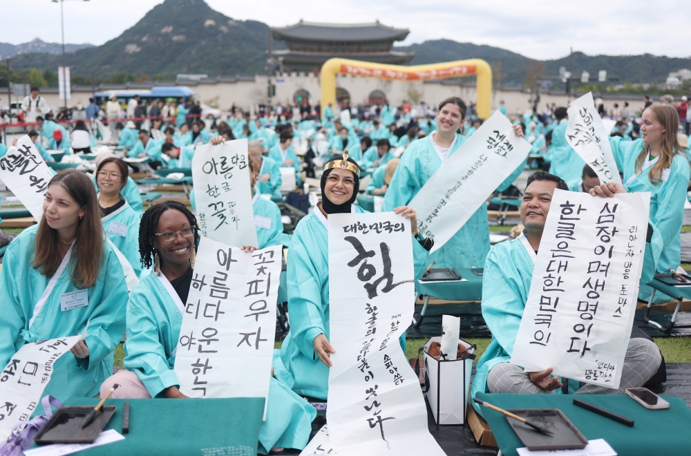 Jumlah peserta Ujian Kemahiran Berbahasa Korea (TOPIK) tahun 2025 telah melampaui 550 ribu orang. Pada tanggal 9 Oktober 2025 bertepatan dengan Hari Hangeul, para peserta asing terlihat sedang menunjukkan tulisan hangeul mereka dalam Lomba Kaligrafi Peringatan 579 Tahun Penciptaan Hangeul yang digelar di Gwanghwamun, Seoul. (Yonhap News)