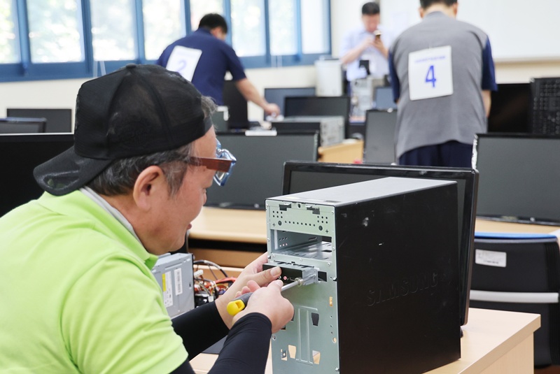 Para peserta terlihat sedang memperbaiki komputer dalam ajang Kompetisi Keterampilan Penyandang Disabilitas yang digelar pada tanggal 25 Mei 2025 di Busan. (Yonhap News)