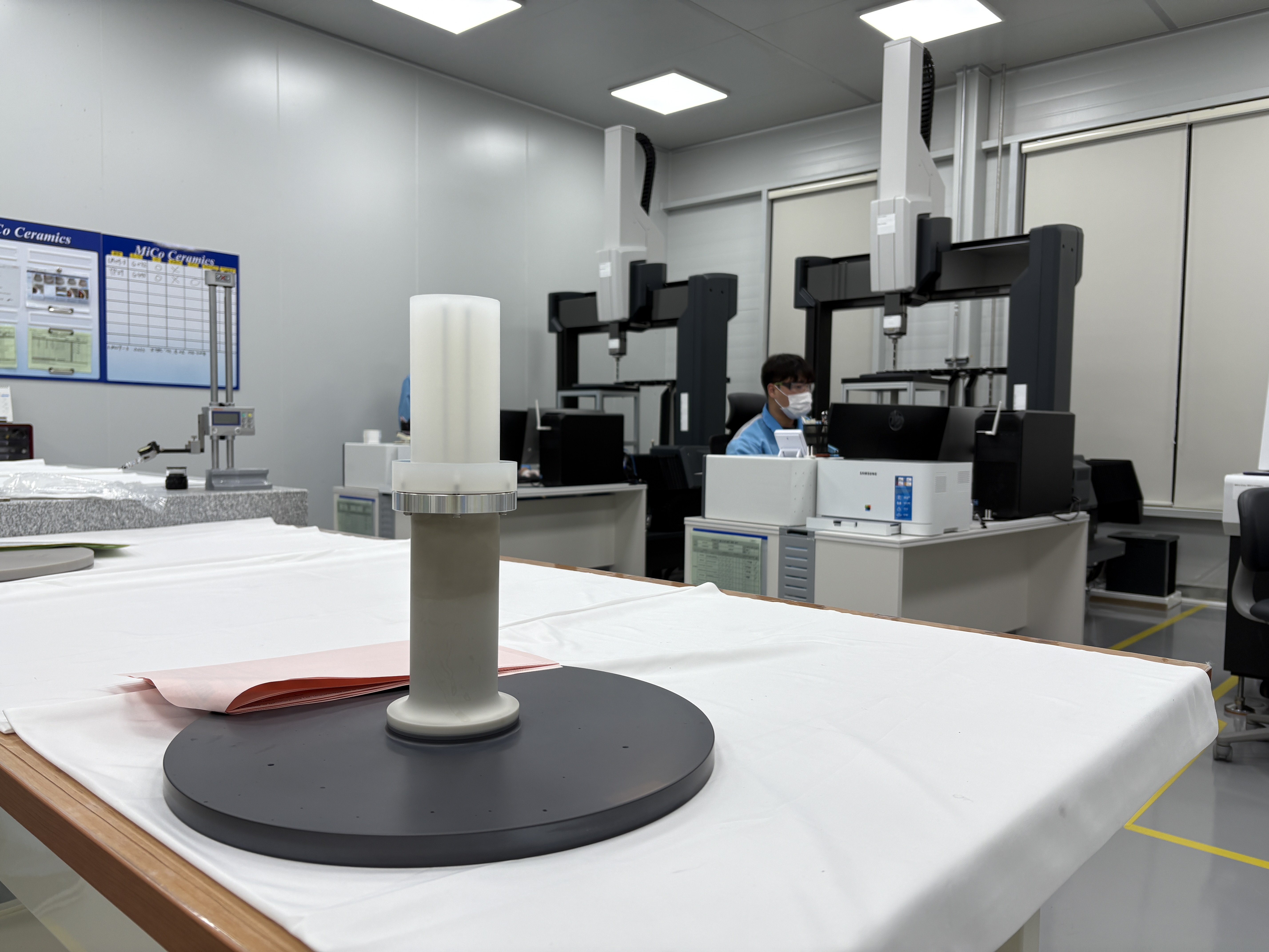 Seorang pegawai MiCo Ceramics terlihat sedang mengukur besar komponen pemanas aluminium nitrida yang akan digunakan di peralatan semikonduktor pada tanggal 6 November 2025 di ruang uji coba kualitas produk yang terletak di pabrik nomor 4 Kota Gangneung, Provinsi Gangwon. Pemeriksaan dimensi presisi adalah proses utama yang dilakukan untuk memastikan bahwa produk terkait sudah dibuat sesuai dengan standar desainnya.  