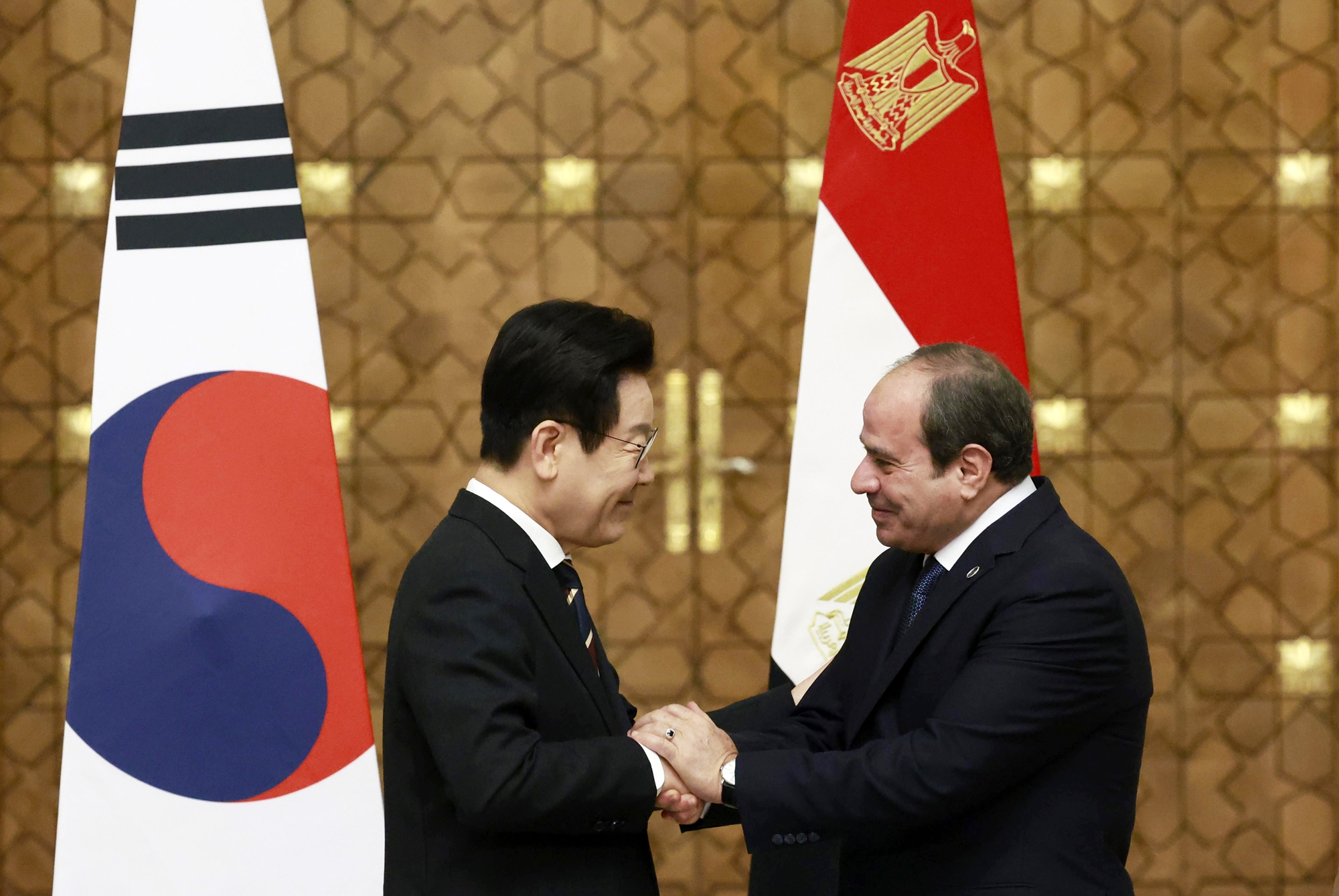 Presiden Lee Jae Myung (kiri) dan Presiden Mesir, Abdel Fattah El-Sisi, berjabat tangan dalam konferensi pers yang digelar pada tanggal 20 November 2025 (waktu setempat) di Istana Kepresidenan Al Ittihadiya, Kairo, Mesir. (Yonhap News)