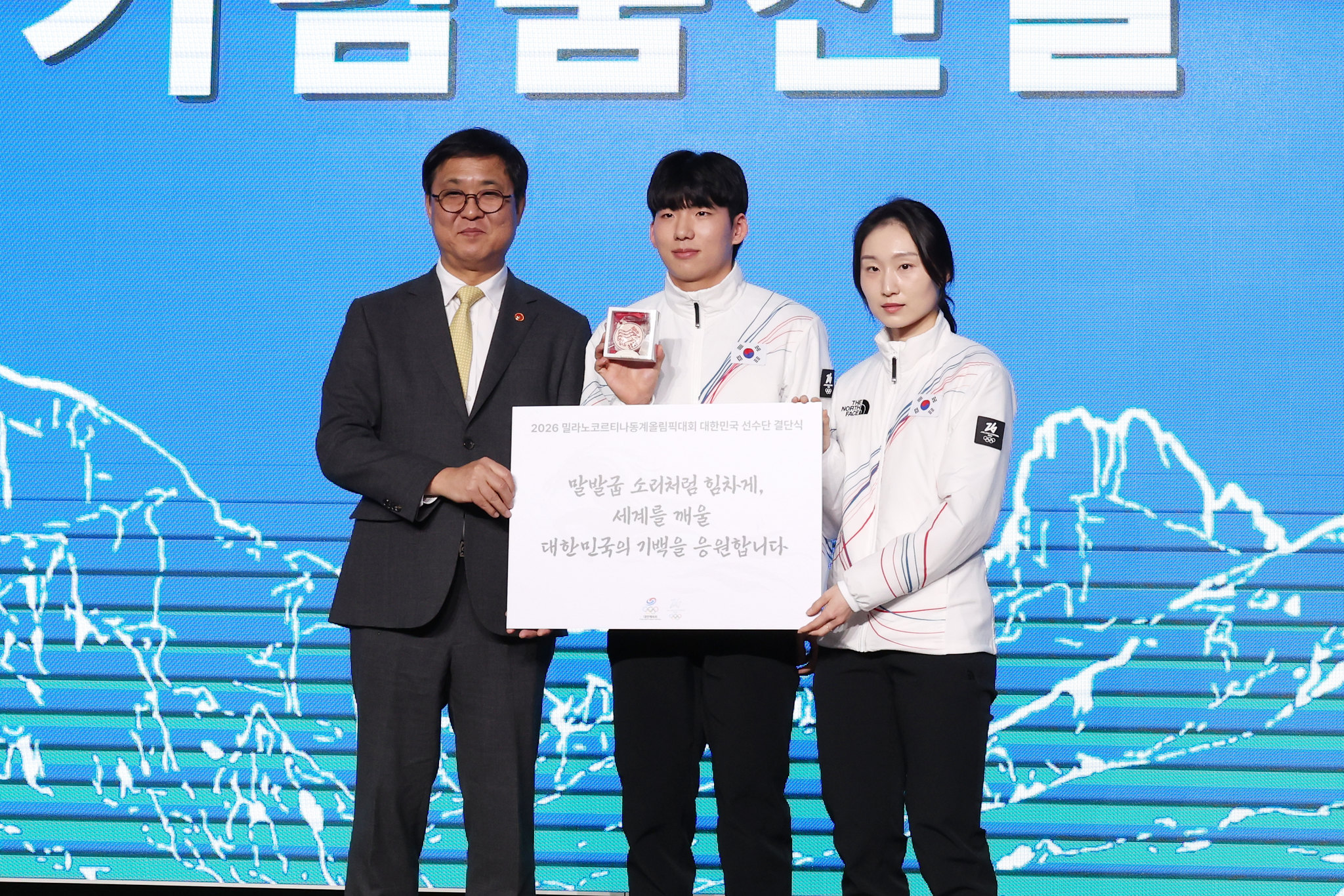 Menteri Kebudayaan, Olahraga, dan Pariwisatam Chae Hwi-young, menyampaikan pesan semangat dan hadiah kepada Chung Jaewon (tengah) dan Choi Min-jeong dalam upacara pelepasan kontingen Milano-Cortina 2026 yang digelar pada tanggal 22 Januari 2026 di Seoul Olympic Parktel, Songpa-gu, Seoul.