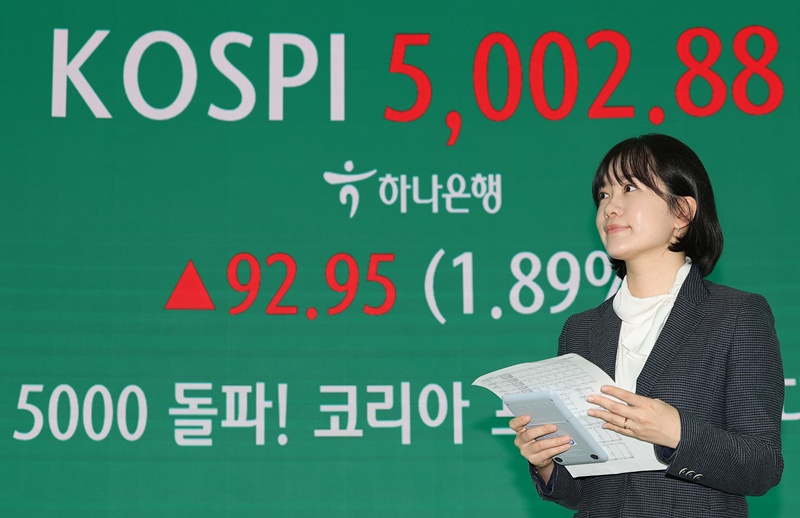 Pada sore hari tanggal 22 Januari 2026, sebuah pengumuman terkait terobosan indeks KOSPI ke level 5.000 ditampilkan pada papan informasi di ruang dealing kantor pusat Hana Bank di Jung-gu, Seoul. (Yonhap News)