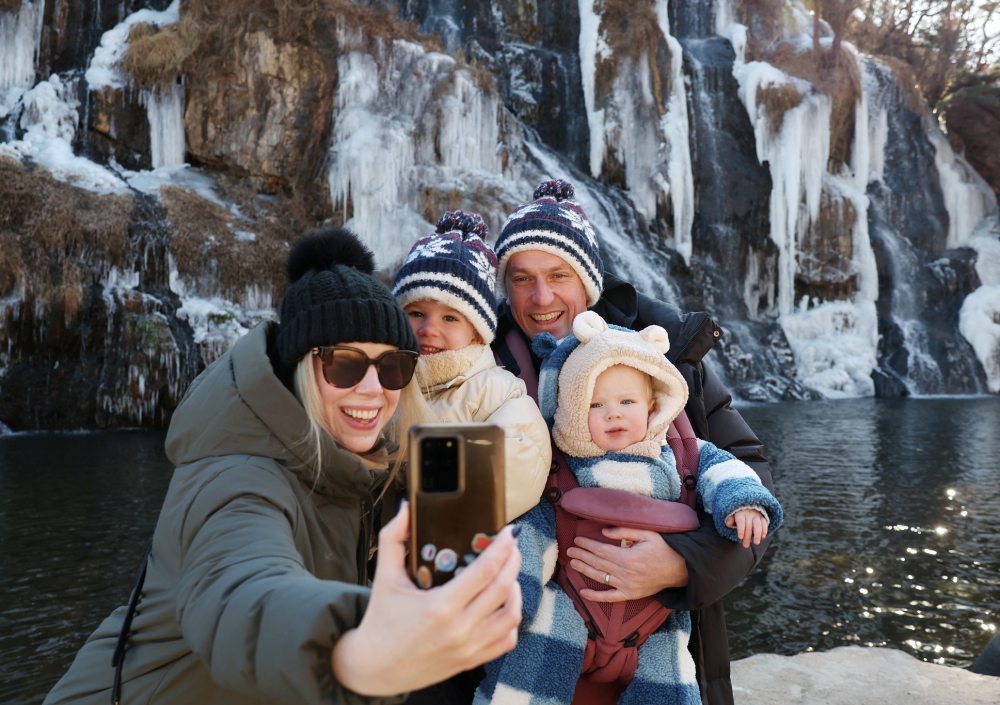 Batas maksimal kartu prabayar khusus wisatawan asing yang berkunjung ke Korea dinaikkan menjadi 1 juta won.. Foto di atas menunjukkan para wisatawan asing yang berpose pada tanggal 7 Januari 2026 di depan Air Terjun Hongjecheon, Seodaemun-gu, Seoul. (Lee Jeong Woo)