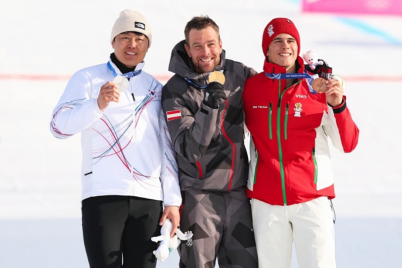 Kim Sangkyum berpose setelah menerima medali perak setelah berhasil menempati posisi kedua dalam babak final snowboard slalom raksasa paralel putra Olimpiade Musim Dingin Milano-Cortina 2026 yang digelar pada tanggal 8 Februari 2026 (waktu setempat) di Livigno Snow Park, Italia. Dari kiri ke kanan: Kim, Karl Benjamin (Austria), dan Zamfirov Tervel (Bulgaria).  