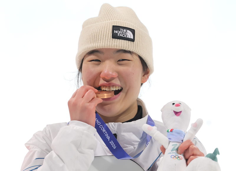 Yu Seungeun menggigit medali perunggu yang ia dapatkan dalam babak final snowboard big air putri Olimpiade Musim Dingin Milano-Cortina 2026 yang diselenggarakan pada tanggal 9 Februari 2026 (waktu setempat) di Livigno Snow Park, Italia. (Yonhap News)  