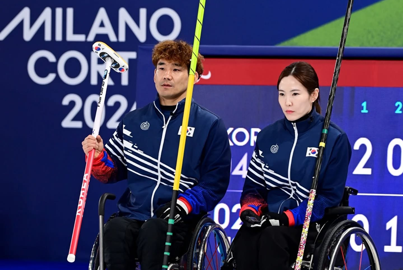 Lee Yongsuk (kiri) dan Baek Hyejin bersiap sebelum pertandingan curling kursi roda ganda campuran.  