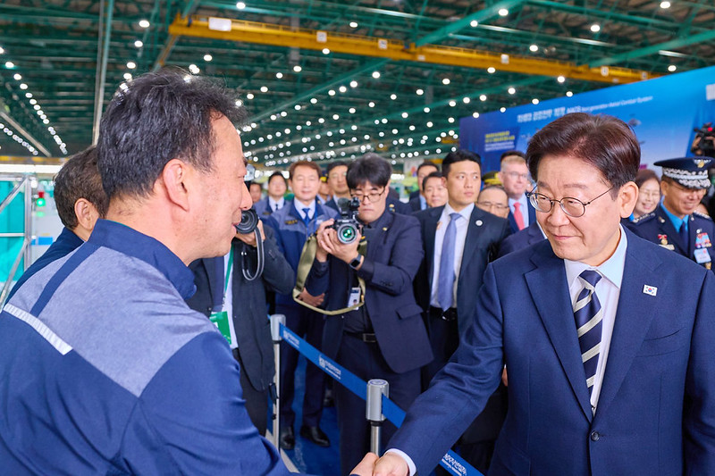 Presiden Lee Jae Myung meninjau fasilitas produksi pesawat sayap tetap di Korea Aerospace Industries (KAI) di Sacheon, Provinsi Gyeongsangnam, pada tanggal 25 Maret 2026, seraya memberikan semangat kepada para pekerja di lapangan.
