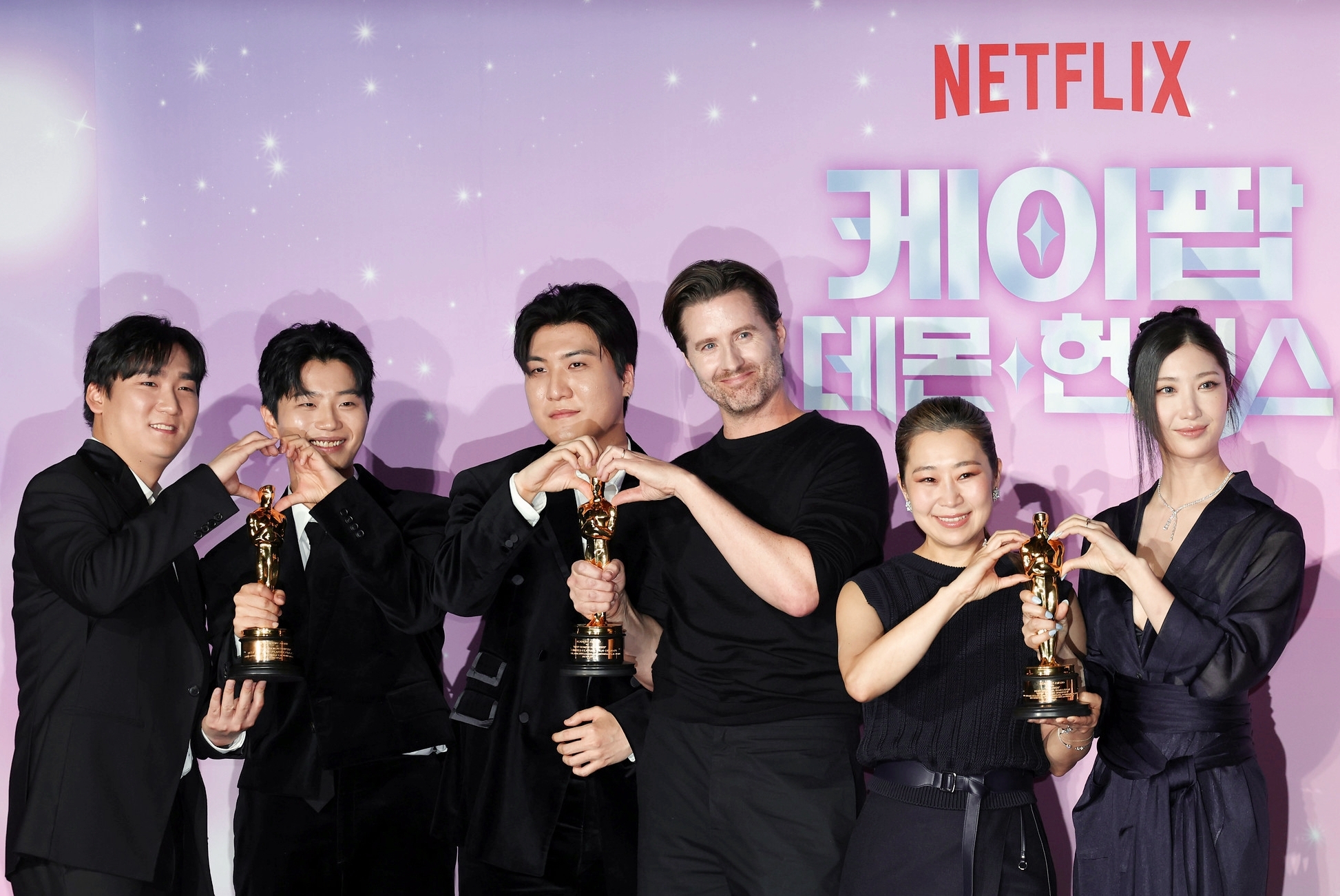 Untuk merayakan penghargaan Oscar yang didapat, tim KPop Demon Hunters menggelar konferensi pers pada tanggal 1 April 2026 di CGV Yongsan I'Park Mall, Yongsan-gu, Seoul. Dari kiri ke kanan: Nam Hee Dong, Lee Yu Han, Kwak Joong Gyu, Chris Appelhans, Maggie Kang, EJAE.